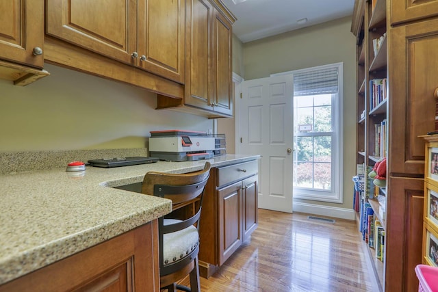 kitchen with light stone countertops and light hardwood / wood-style flooring