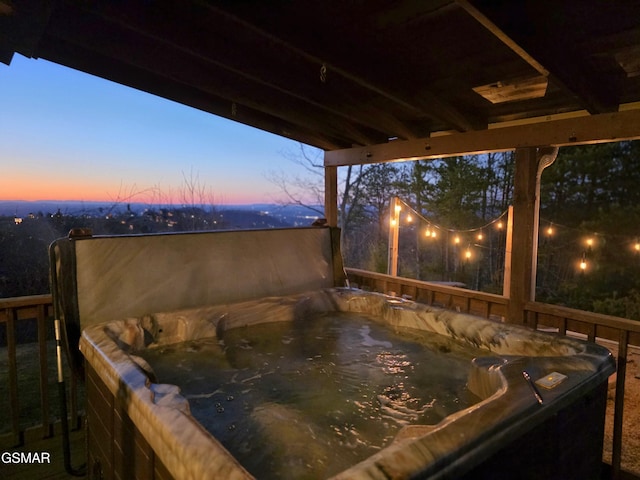 patio terrace at dusk featuring a hot tub