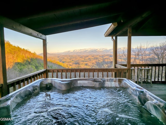 deck with a mountain view and a hot tub