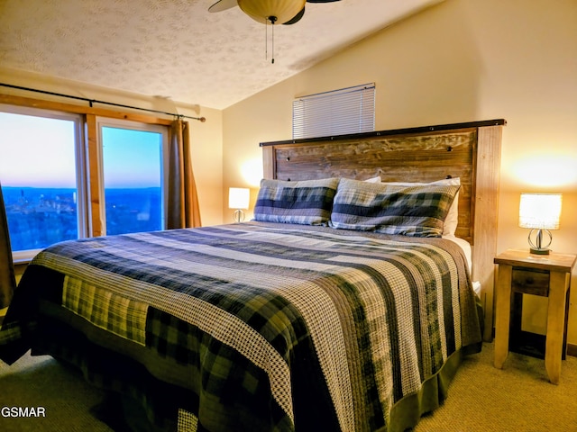 carpeted bedroom with ceiling fan, vaulted ceiling, and a textured ceiling