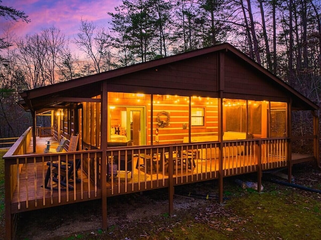 rear view of property featuring a wooden deck