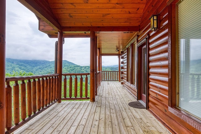 wooden terrace with a mountain view and covered porch