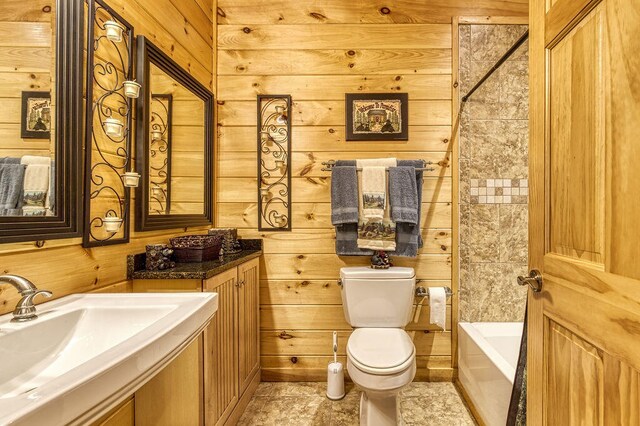 bathroom with a bathtub, wood walls, toilet, and sink