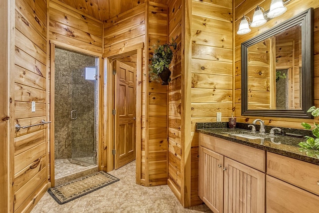 bathroom featuring vanity, wood walls, and a shower with shower door