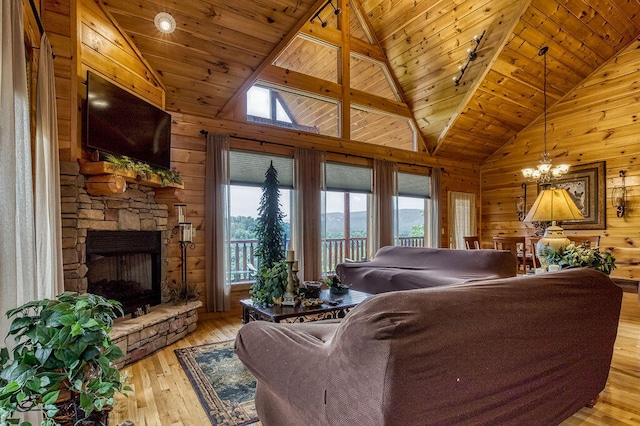 living room featuring light hardwood / wood-style floors, a stone fireplace, wood ceiling, and wooden walls