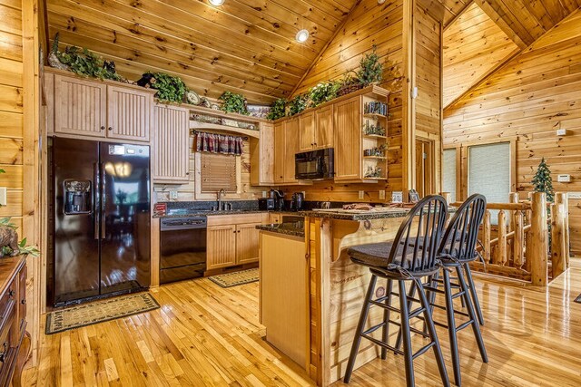 kitchen featuring sink, high vaulted ceiling, wooden walls, black appliances, and light wood-type flooring