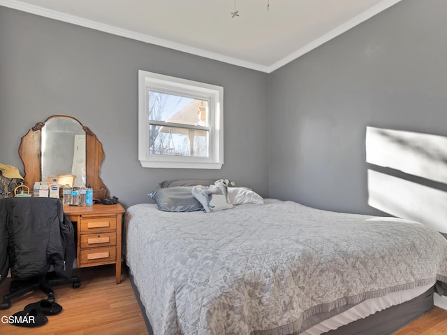 bedroom featuring crown molding and light wood-type flooring