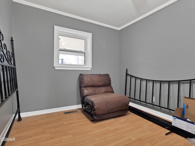 sitting room featuring ornamental molding and hardwood / wood-style floors