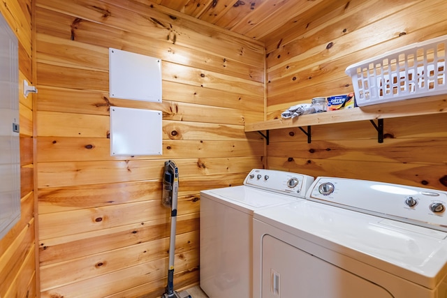 laundry room featuring washer and dryer, wooden ceiling, and wood walls