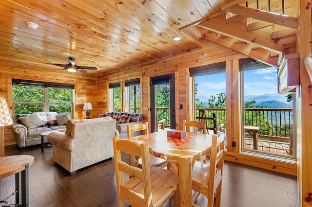 dining space featuring a mountain view, ceiling fan, wood ceiling, and a wealth of natural light