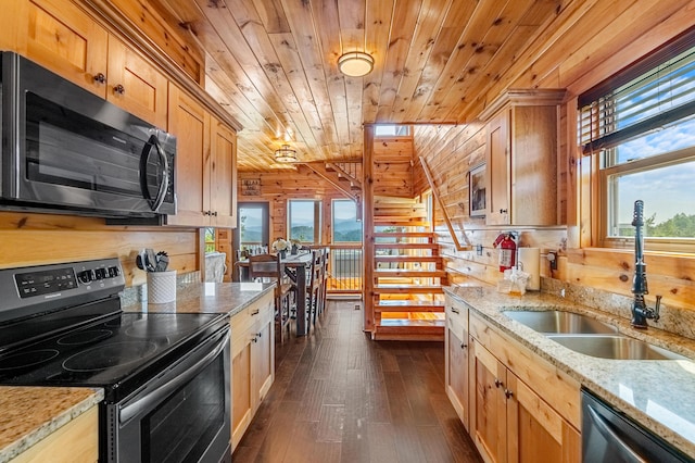 kitchen with wooden ceiling, sink, wooden walls, light stone counters, and stainless steel appliances