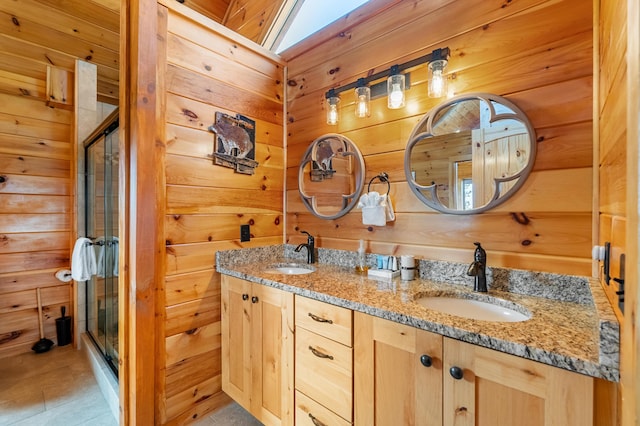 bathroom featuring wooden walls, tile patterned flooring, vanity, and a shower with shower door