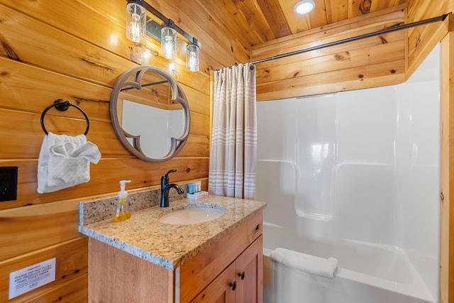 bathroom featuring shower / bath combo with shower curtain, vanity, and wooden walls