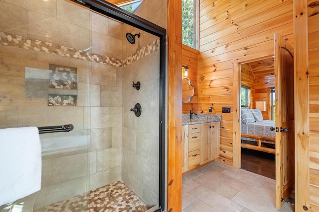 bathroom with tile patterned floors, vanity, wood walls, and an enclosed shower