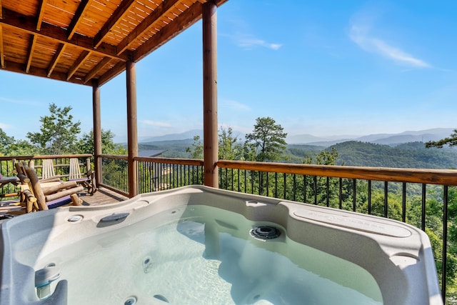 wooden terrace with a mountain view and a hot tub