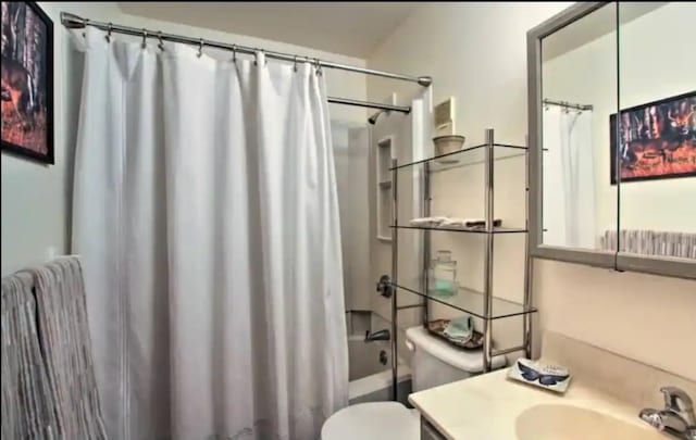 full bathroom featuring vanity, shower / bathtub combination with curtain, and toilet