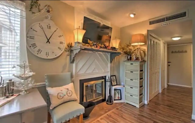 sitting room with hardwood / wood-style floors and vaulted ceiling