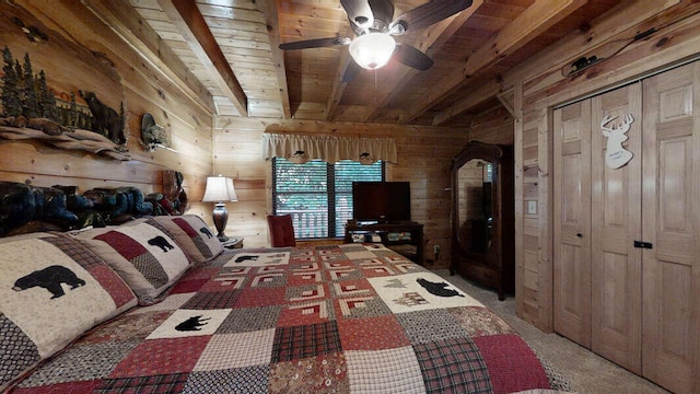 bedroom featuring beam ceiling, ceiling fan, wood walls, carpet floors, and wood ceiling