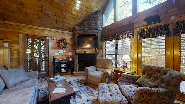 living room with high vaulted ceiling, a stone fireplace, wooden walls, hardwood / wood-style flooring, and wood ceiling