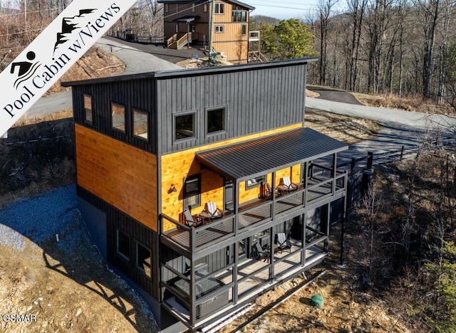 back of property with metal roof and a balcony