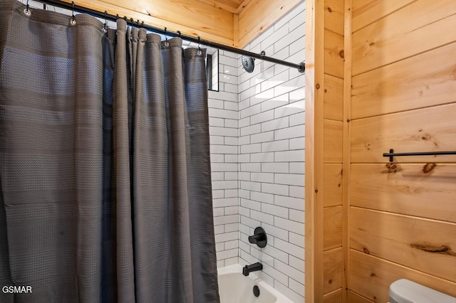 bathroom with shower / bath combo with shower curtain and wooden walls