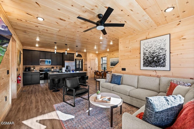 living room featuring wood ceiling, ceiling fan, wood-type flooring, and wooden walls