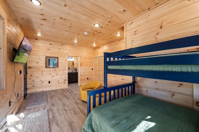 unfurnished bedroom featuring wooden ceiling, light wood-style flooring, recessed lighting, wooden walls, and ensuite bath