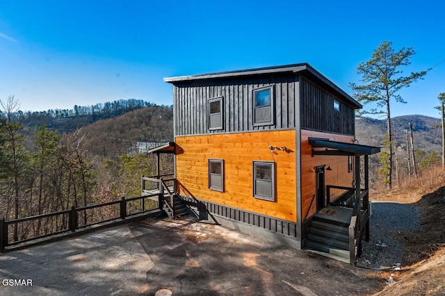 view of side of home featuring fence and a mountain view