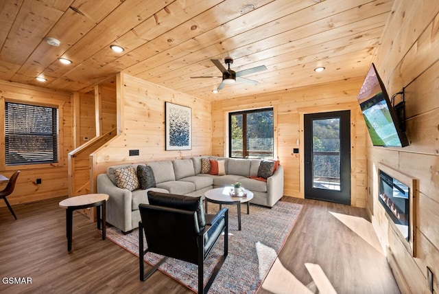 living room with wooden ceiling, recessed lighting, wood walls, a fireplace, and wood finished floors