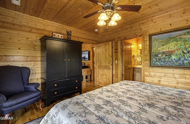 bedroom with visible vents, wood walls, wood finished floors, wood ceiling, and a ceiling fan