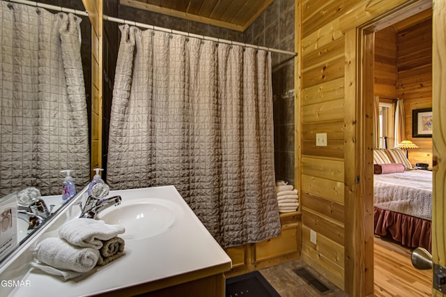 full bath with wood walls, visible vents, and vanity