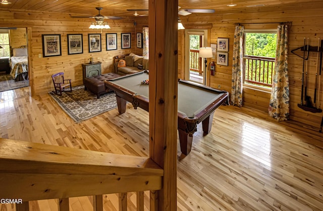 playroom with wooden ceiling, ceiling fan, wood-type flooring, and wood walls