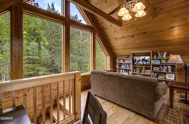 living room with lofted ceiling with beams, a ceiling fan, a wealth of natural light, and hardwood / wood-style flooring