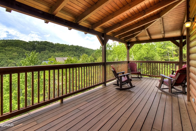 wooden terrace featuring a forest view