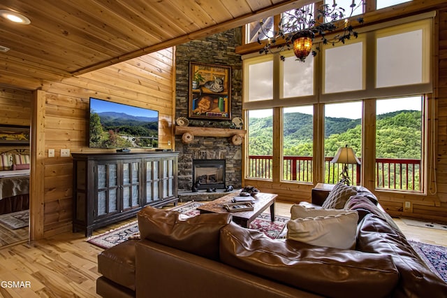 living room featuring wood ceiling, a stone fireplace, wood-type flooring, lofted ceiling, and wooden walls