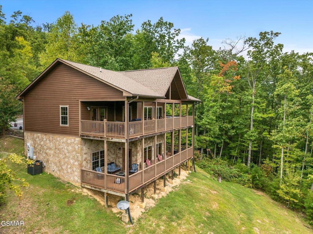 back of house with a lawn and a deck