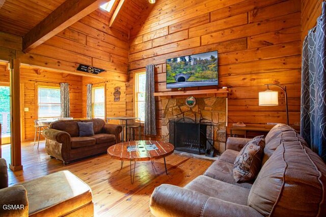 3637 Marshall Ln, Sevierville, TN 37862 - living room with wooden walls, hardwood / wood-style flooring, a stone fireplace, a wood ceiling with exposed beams, and high vaulted ceiling