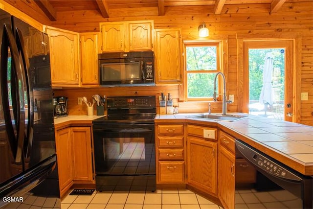 3637 Marshall Ln, Sevierville, TN 37862 - kitchen featuring black appliances, tile counters, beamed ceiling, wooden walls, and light tile patterned flooring