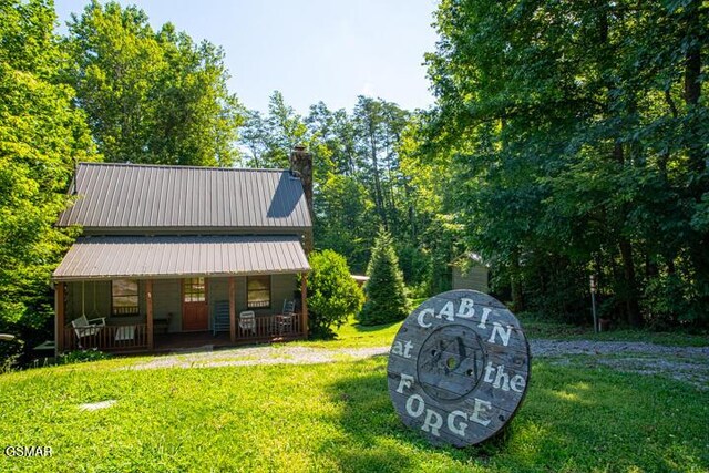 3637 Marshall Ln, Sevierville, TN 37862 - rear view of property with covered porch, a yard, a chimney, and a metal roof