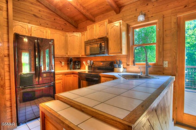 3637 Marshall Ln, Sevierville, TN 37862 - kitchen with black appliances, tile counters, wood ceiling, wood walls, and a peninsula