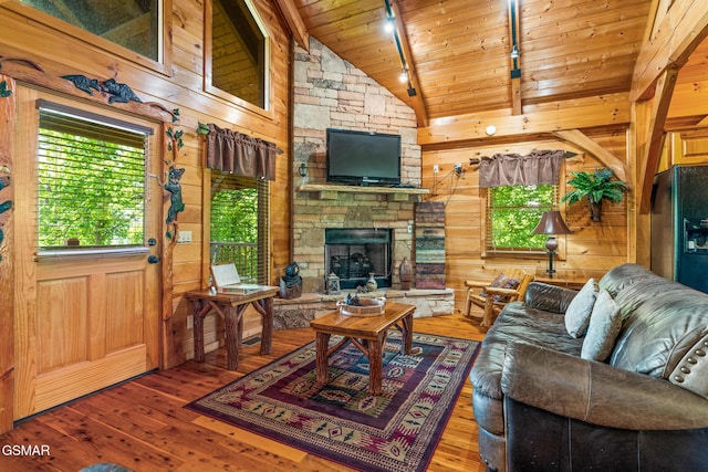 2494 Black Bear Ridge Way, Sevierville, TN 37862 - living area featuring hardwood / wood-style flooring, wooden ceiling, track lighting, wood walls, and a stone fireplace
