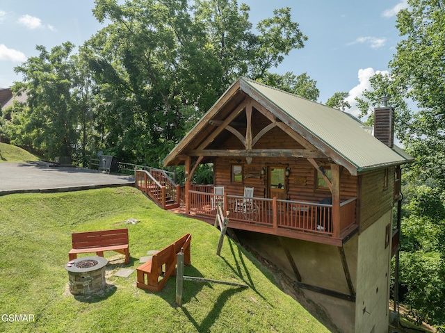 2494 Black Bear Ridge Way, Sevierville, TN 37862 - view of front of property with a fire pit, a front lawn, a deck, a metal roof, and a chimney