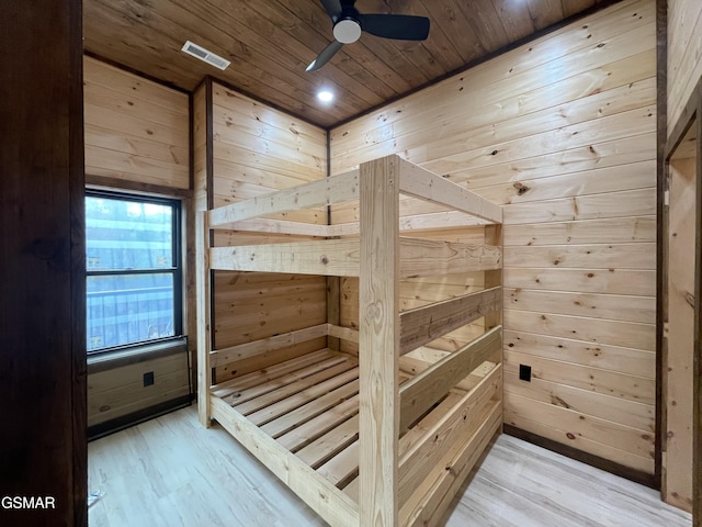 bedroom with wood walls, ceiling fan, wooden ceiling, and light wood-type flooring