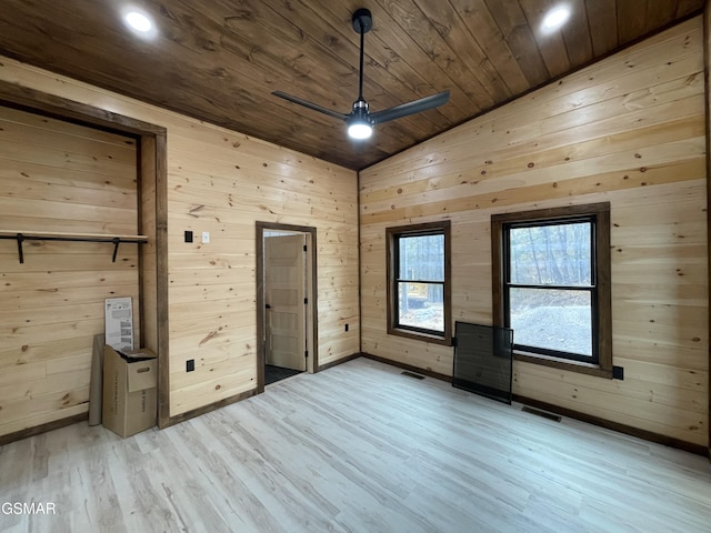 unfurnished bedroom featuring wood walls, light hardwood / wood-style flooring, wooden ceiling, and vaulted ceiling