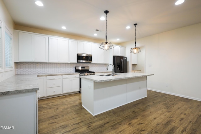 kitchen with dark hardwood / wood-style flooring, stainless steel appliances, a kitchen island with sink, white cabinetry, and hanging light fixtures