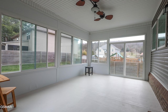 unfurnished sunroom with ceiling fan