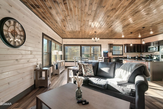 living room featuring an inviting chandelier, wood finished floors, wooden ceiling, baseboards, and wooden walls