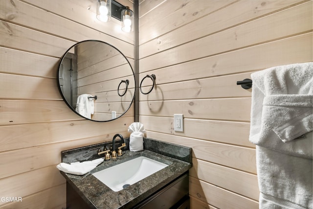 bathroom with vanity and wood walls