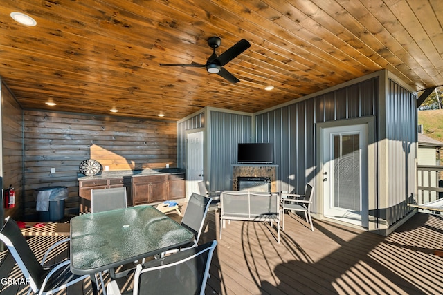 wooden deck with outdoor dining space and ceiling fan