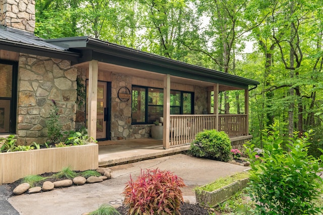 1008 Glades Rd, Gatlinburg, TN 37738 - doorway to property featuring stone siding, a porch, metal roof, and a standing seam roof